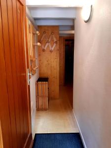 a hallway with a door to a room with hangers at Les Perthuis - Portes du Soleil in Châtel