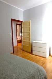 1 dormitorio con 1 cama, vestidor y puerta en Yellow Door 2, en Ponferrada