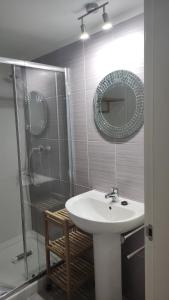 a bathroom with a sink and a shower and a mirror at La LLana Nova in Ribes de Freser