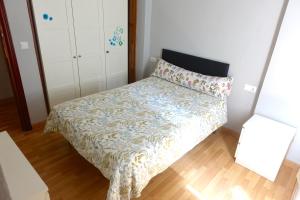 Dormitorio pequeño con cama con colcha de flores en Yellow Door 2, en Ponferrada