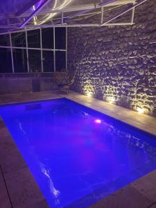 einen Pool mit blauen Lichtern in einem Zimmer in der Unterkunft Château de Saint Bonnet les Oules in Saint-Bonnet-les-Oules