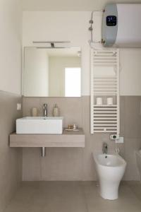 a white bathroom with a sink and a mirror at Residenza SubitoSanto - Appartamento 2A "Angelina" in Padova