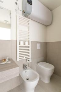 a white bathroom with a toilet and a sink at Residenza SubitoSanto - Appartamento 2A "Angelina" in Padova