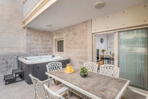 a patio with a table and chairs and a hot tub at Sea U Jerusalem Mahane Yehuda Apartment Hotel in Jerusalem
