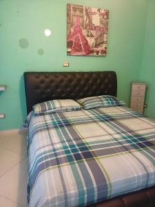 a bedroom with a bed with a checkered blanket at Dimora Volturno in Vasto