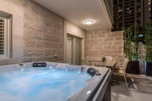 a hot tub in a room with a table and chairs at Sea U Jerusalem Mahane Yehuda Apartment Hotel in Jerusalem