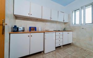 a kitchen with white cabinets and a counter top at Milios Studios in Megálon Choríon