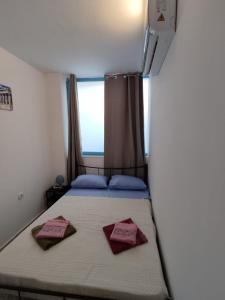 een slaapkamer met een bed met 2 kussens erop bij PURE URBAN ACROPOLIS METRO PETRALONA in Athene