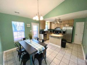 uma cozinha com paredes verdes e uma mesa e cadeiras em The Best Getaway Friends & Family Hangout!!! em Jacksonville