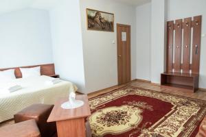 a bedroom with a bed and a living room at Tarmansky Hotel in Tyumen