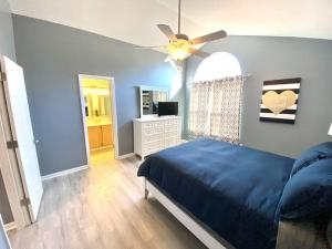 um quarto com uma cama azul e uma ventoinha de tecto em The Best Getaway Friends & Family Hangout!!! em Jacksonville