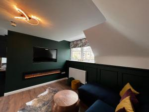 a living room with a green wall with a fireplace at Chapel Cross Guesthouse in Roslin