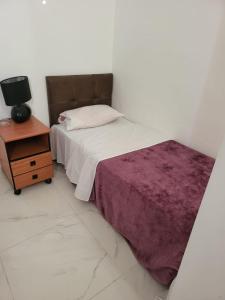 a white room with a bed and a nightstand with a bed sidx sidx sidx at Jerusalem M in Jerusalem