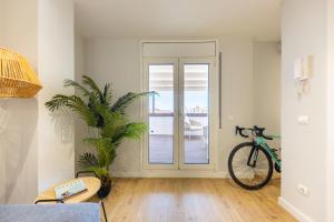 a bike parked in a room with a door at Bravissimo Eiximenis, with beautiful terrace and views in Girona