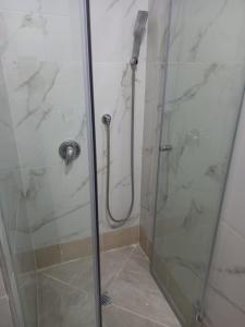 La salle de bains est pourvue d'une douche avec une porte en verre. dans l'établissement Jerusalem M, à Jérusalem