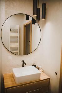 a bathroom with a white sink and a mirror at Nadolnik apartment in Poznań