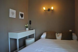 a bedroom with a bed and a desk and a table at Hotel Les Voyageurs in Les Sables-d'Olonne