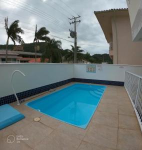 ein Pool auf der Rückseite eines Hauses in der Unterkunft Apartamento Residencial Mar Azul - praia de Palmas - Governador Celso Ramos-SC in Governador Celso Ramos