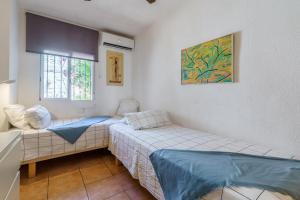 Habitación pequeña con 2 camas y ventana en La Ponderosa 5, en Mijas Costa