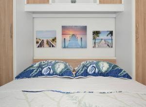 a bed with two blue and white pillows on it at Apartment Charlie in Podstrana