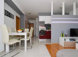 uma cozinha e sala de estar com mesa e cadeiras em Apartment Charlie em Podstrana