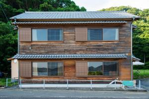 uma casa de madeira com telhado de metal em 大砂荘 OZUNA CAMP and LODGE em Kaiyo