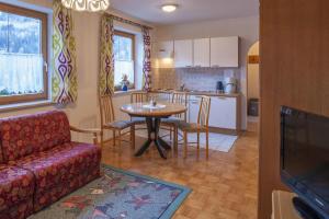 ein Wohnzimmer und eine Küche mit einem Tisch und einem Sofa in der Unterkunft Haus Schönegger in Dorfgastein
