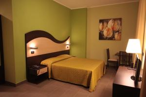Habitación de hotel con cama y silla en Life Sport Hotel en Mentana