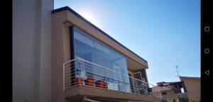 un bâtiment avec une grande fenêtre en verre sur un balcon dans l'établissement Delizioso appartamento nel cuore Castelli Romani, à Marino