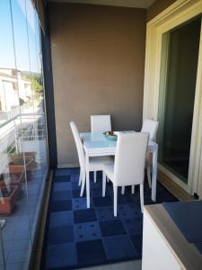 a blue table and white chairs on a balcony at Delizioso appartamento nel cuore Castelli Romani in Marino