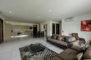 a living room with two couches and a kitchen at Accra Fine Suites - Henrietta's Residences in Accra