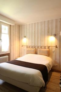 a bedroom with a large white bed with two pillows at Le Vieux Moulin in Hédé
