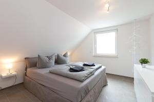 a white bedroom with a bed with a window at Apartment unter den Kiefern 93 in Röbel