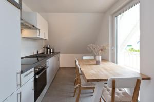 una cucina con tavolo in legno e una sala da pranzo di Apartment unter den Kiefern 93 a Röbel