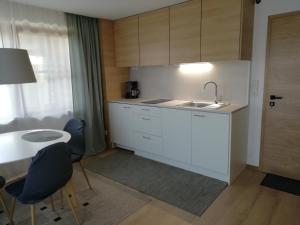 a kitchen with a sink and a table with chairs at Ferienwohnung Anneliese Eckhart in Anger