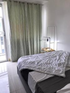 Giường trong phòng chung tại Cozy 2 BR high floor end unit with balcony at SM Southmall