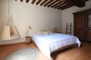 sypialnia z białym łóżkiem i drewnianą podłogą w obiekcie Les Falaises de l'Estran w mieście Dieppe