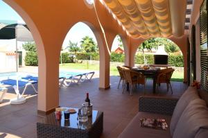 an outdoor patio with a table and chairs and a dining room at Villas Las Golondrinas in Cala'n Bosch