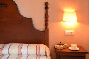 a bedroom with a bed and a table with a lamp at Villas Las Golondrinas in Cala'n Bosch