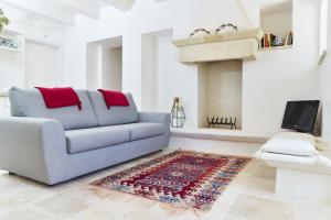 a living room with a couch and a fireplace at Trulleria Tagliente in Alberobello
