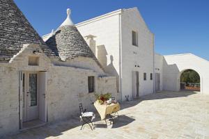 a white building with a table in front of it at Trulleria Tagliente in Alberobello