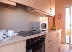 a kitchen with a microwave and a stove top oven at Villas Las Golondrinas in Cala'n Bosch