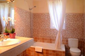 a bathroom with a tub and a sink and a toilet at Villas Las Golondrinas in Cala'n Bosch