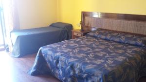 a hotel room with two beds and a desk at Bed and Breakfast Coral Blue in Briatico