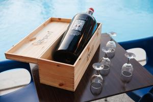 a wooden box with a bottle of wine and glasses on a table at Alea Villas in Kourouta