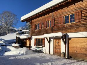 a wooden house with snow on the front of it at Chalet Tschengla in Bürserberg