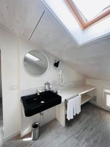baño con lavabo negro y tragaluz en Le Stanze Guesthouse, en Morciano di Romagna