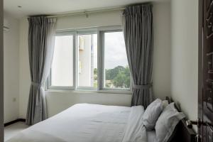 a bedroom with a bed and a window at Accra Fine Suites - Henrietta's Residences in Accra