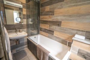 ein Bad mit einer Badewanne, einem Waschbecken und einer Dusche in der Unterkunft Corporate Suite in Hookwood