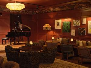 a living room with a piano and tables and chairs at The Ned NoMad in New York